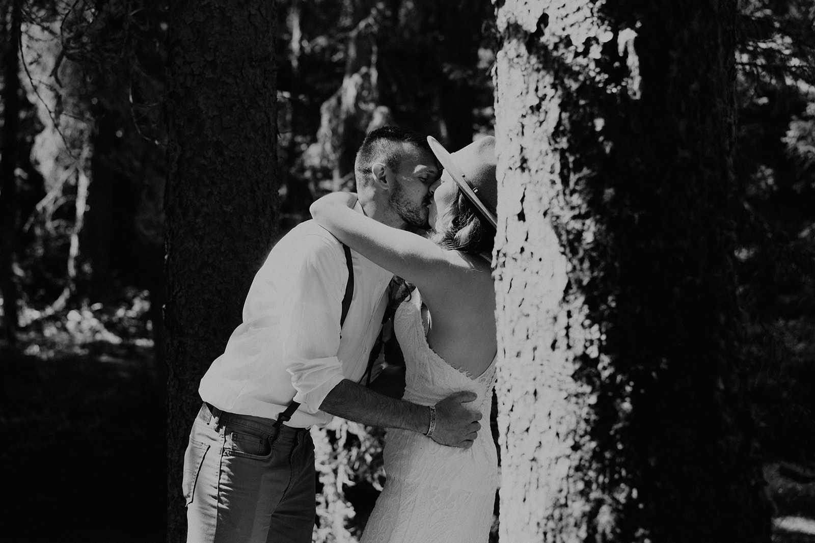 Black and white photo of Adventurous bride and groom kissing in the forests of Colorado