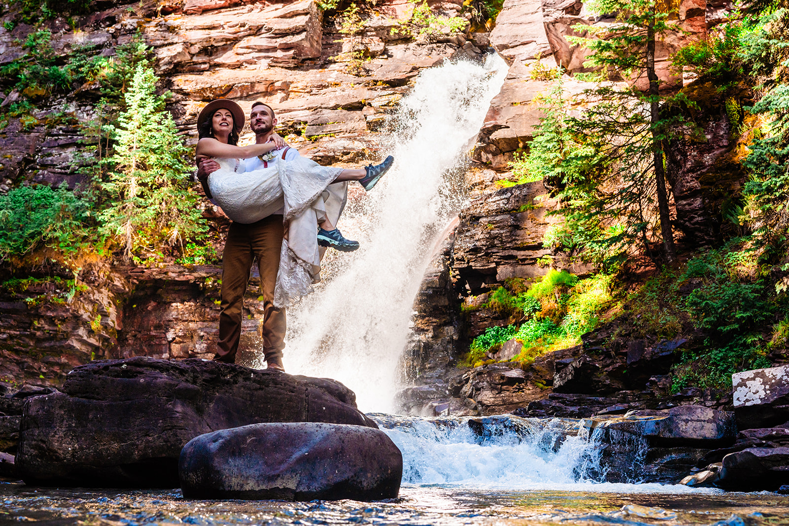 Adventurous bride and groom in the San Juan mountains near a waterfall