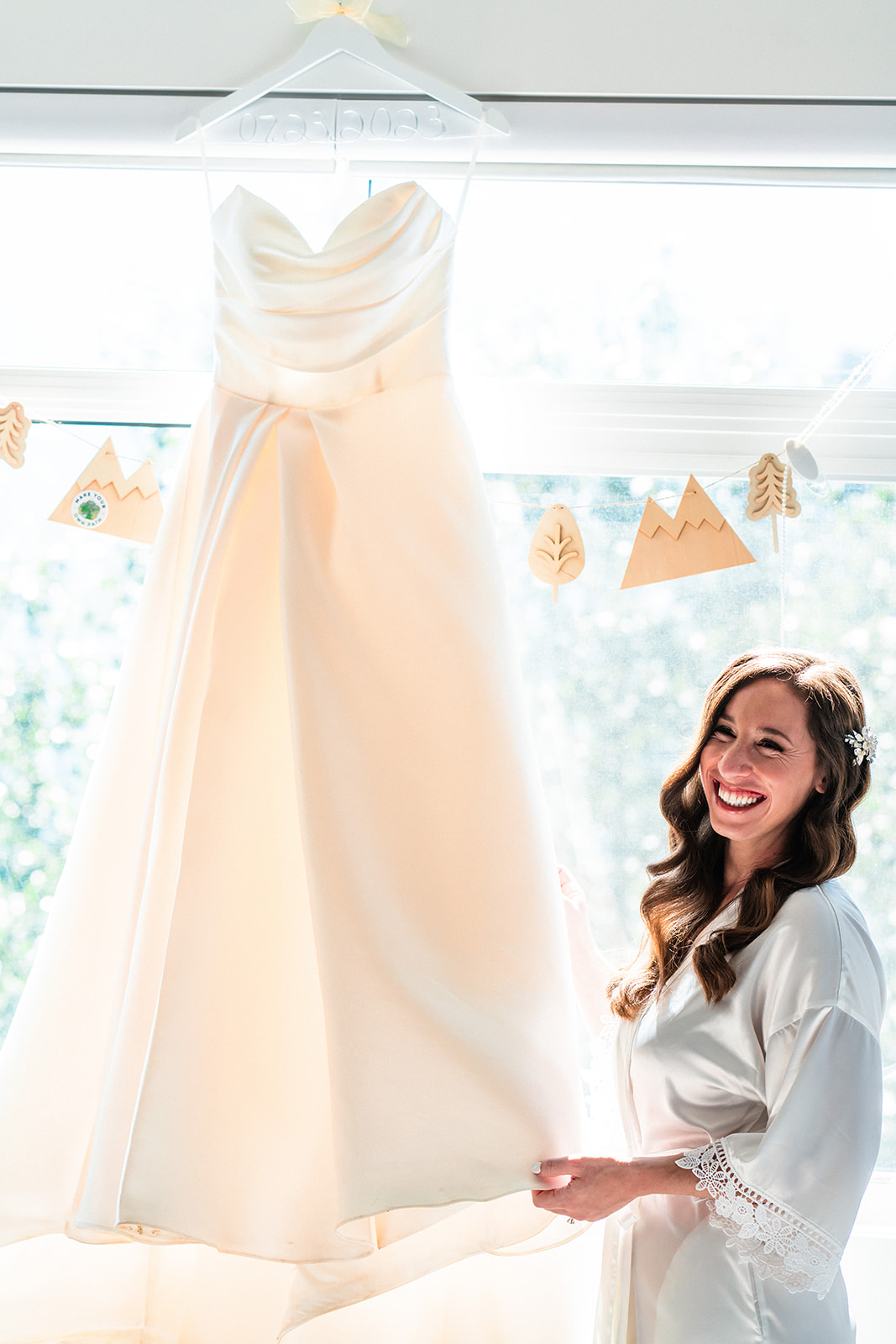 Bride smiling standing next to her strapless wedding dress