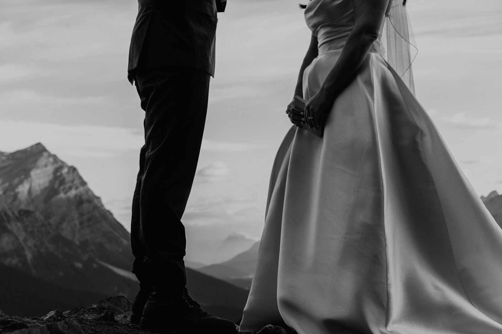 Black and white photo of bride and groom standing exchanging vows