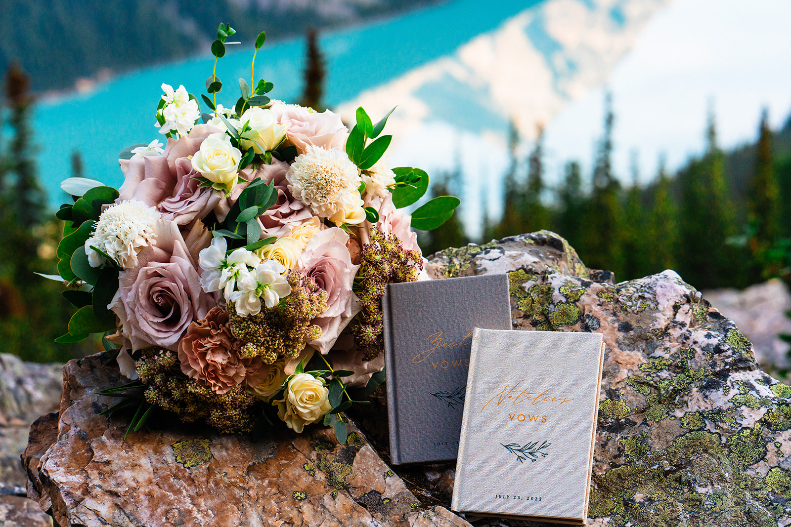 Bride and groom vows and floral bouquet with a view of Banff mountains and lake in the background