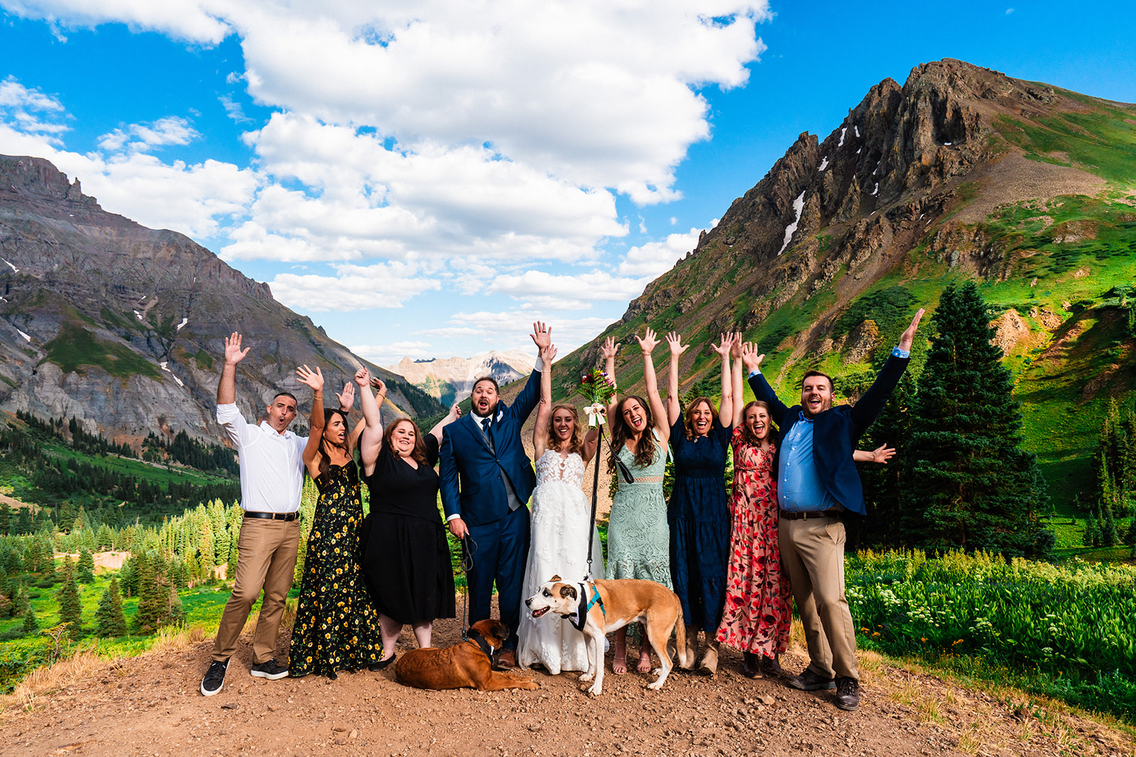 Bride and groom cheering with family, friends, and their pups at Yankee Boy Basin