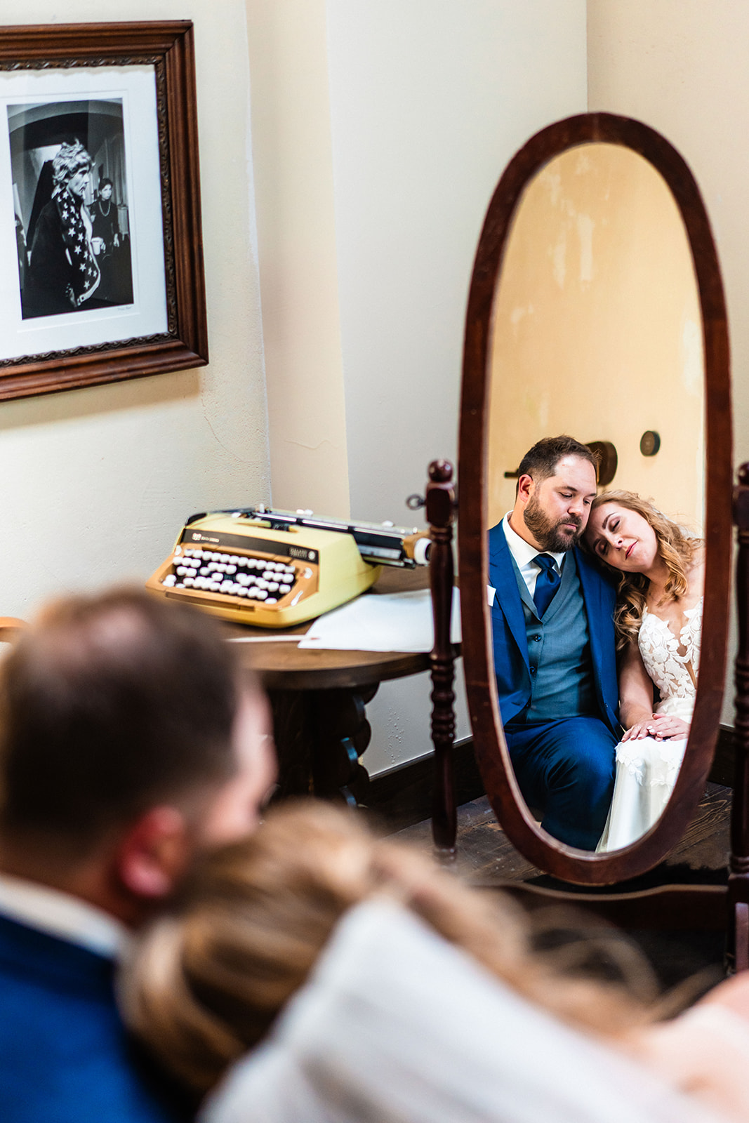 Bride and groom sitting together looking in a mirror