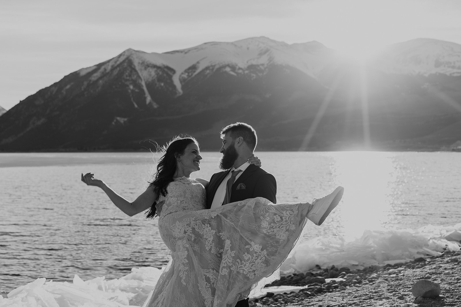 Black and white photo of groom holding bride in front of Twin Lakes