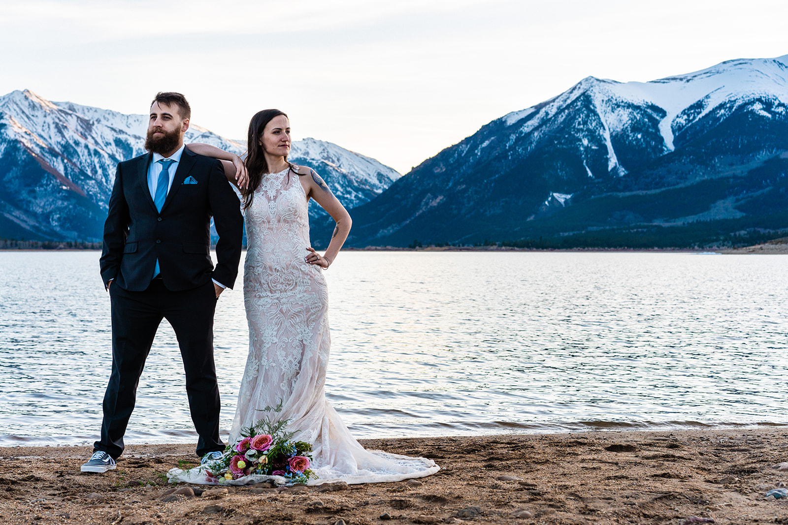 Bride and groom standing side by side at Twin Lakes with the Colorado mountains in the background