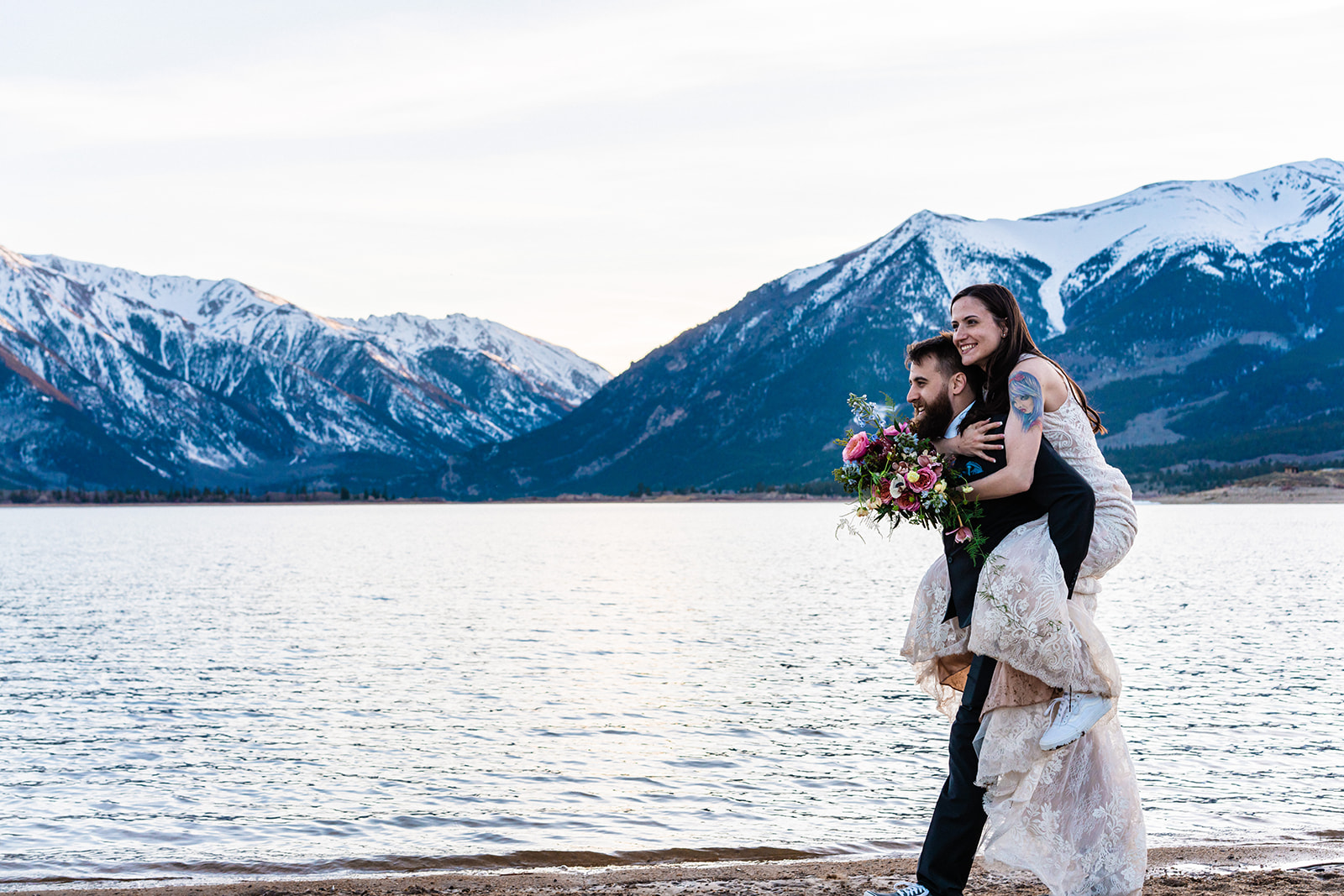 Groom giving bride a piggy back ride at Twin Lakes