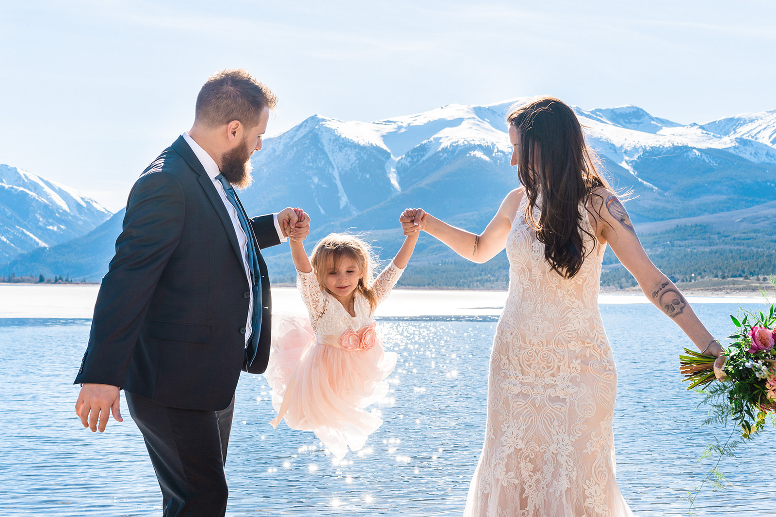 bride and groom swinging their daughter during their Intimate Twin Lakes Elopement in Leadville, CO
