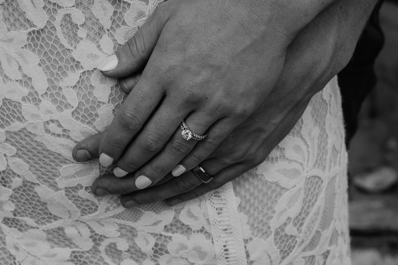 Black and white photo of bride and groom holding hands