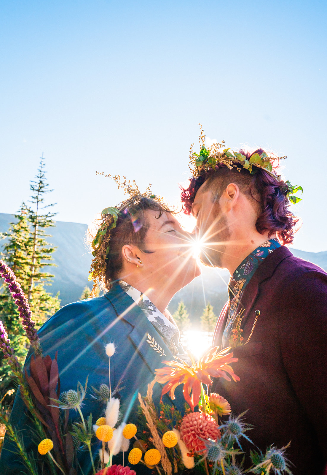 Newlyweds kissing with floral crowns on their heads