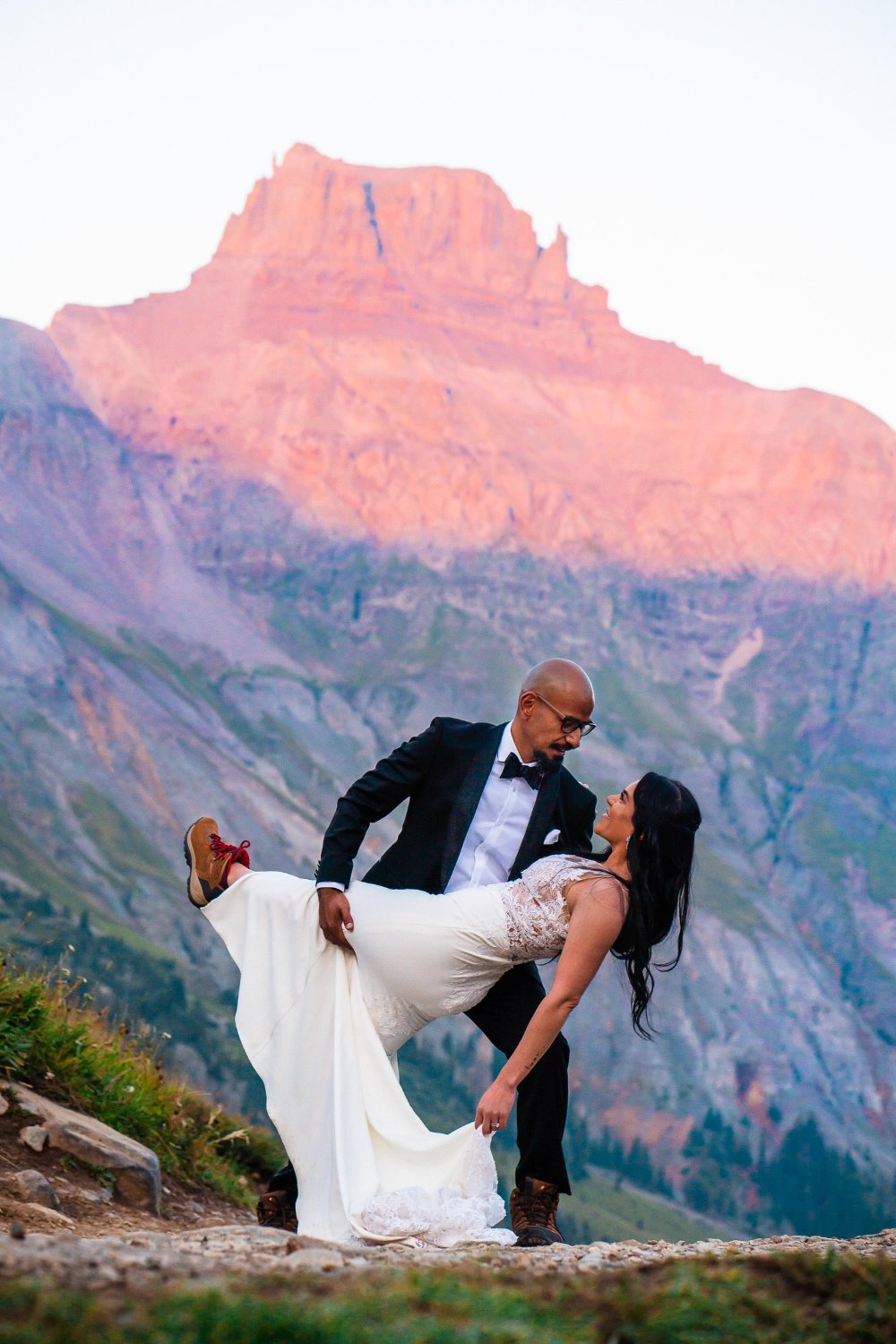 A couple's elopement photos capture them posing in front of a breathtaking mountain backdrop on their special day.