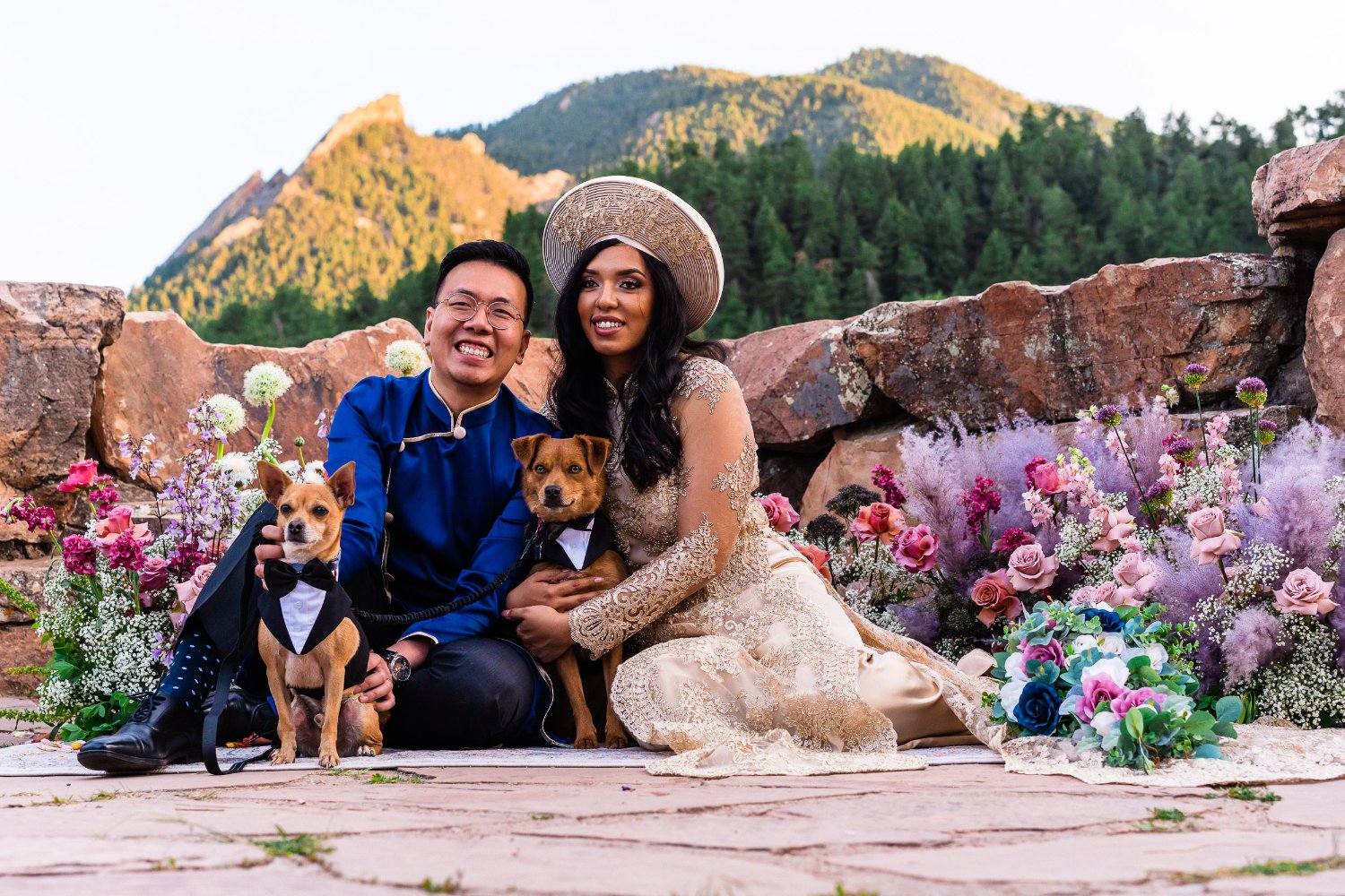 A bride and groom elopement photos with their dogs in front of a mountain.