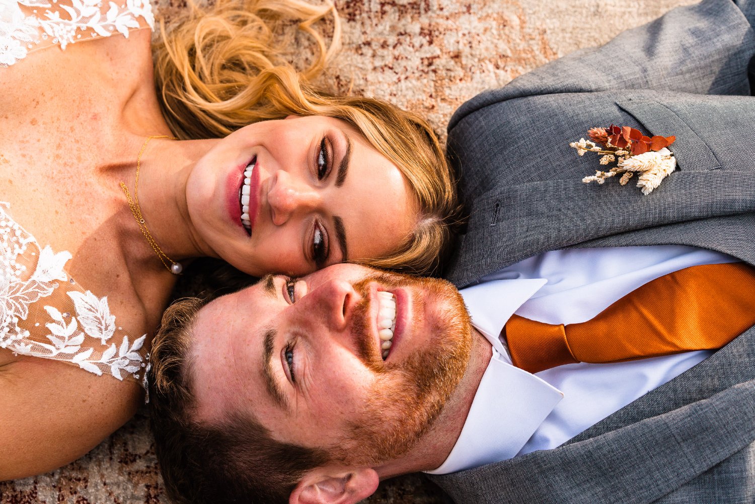 Capturing intimate elopement photos of a bride and groom embracing on the ground.