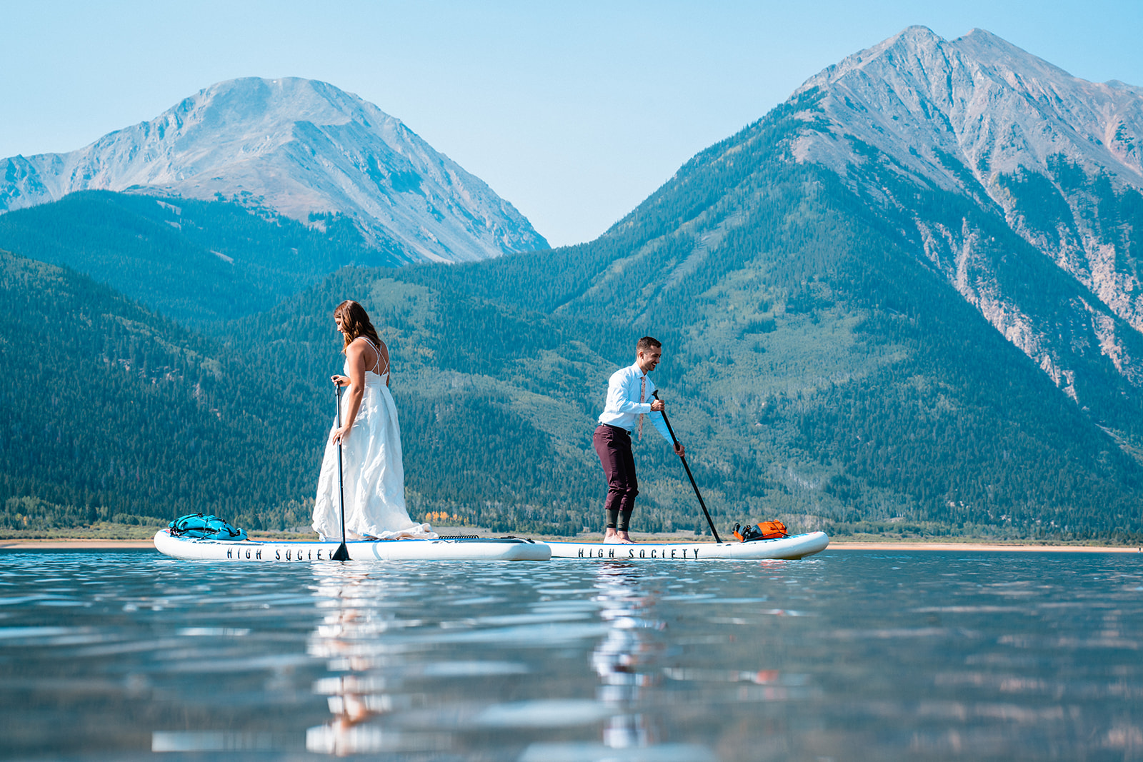 A bride and groom on paddle boards during their Colorado adventure elopement