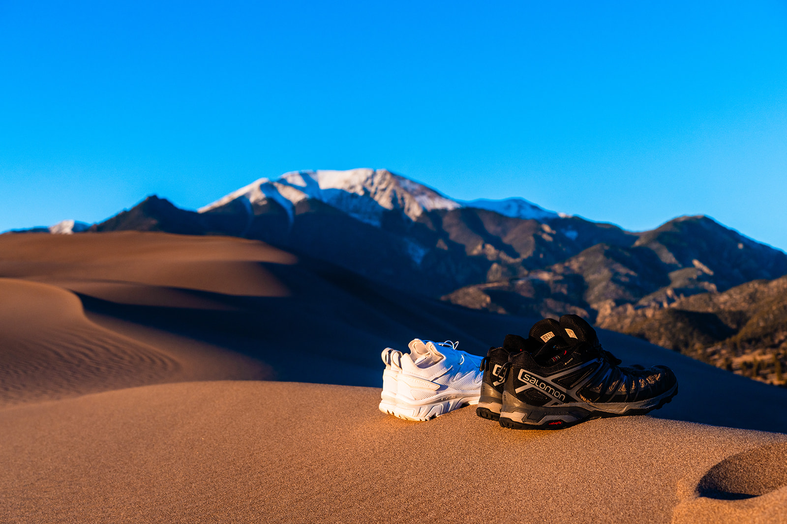 A pair of shoes sitting on top of a sand dune at the Great Sand Dunes.