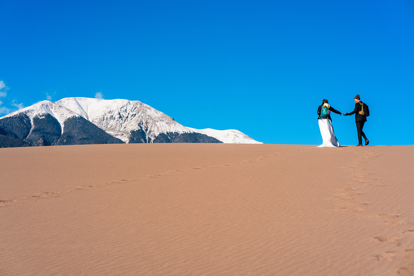 A person standing in a desert at the Great Sand Dunes