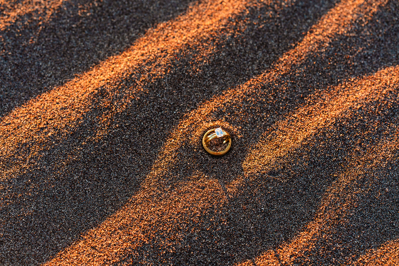 A wedding ring on sand.