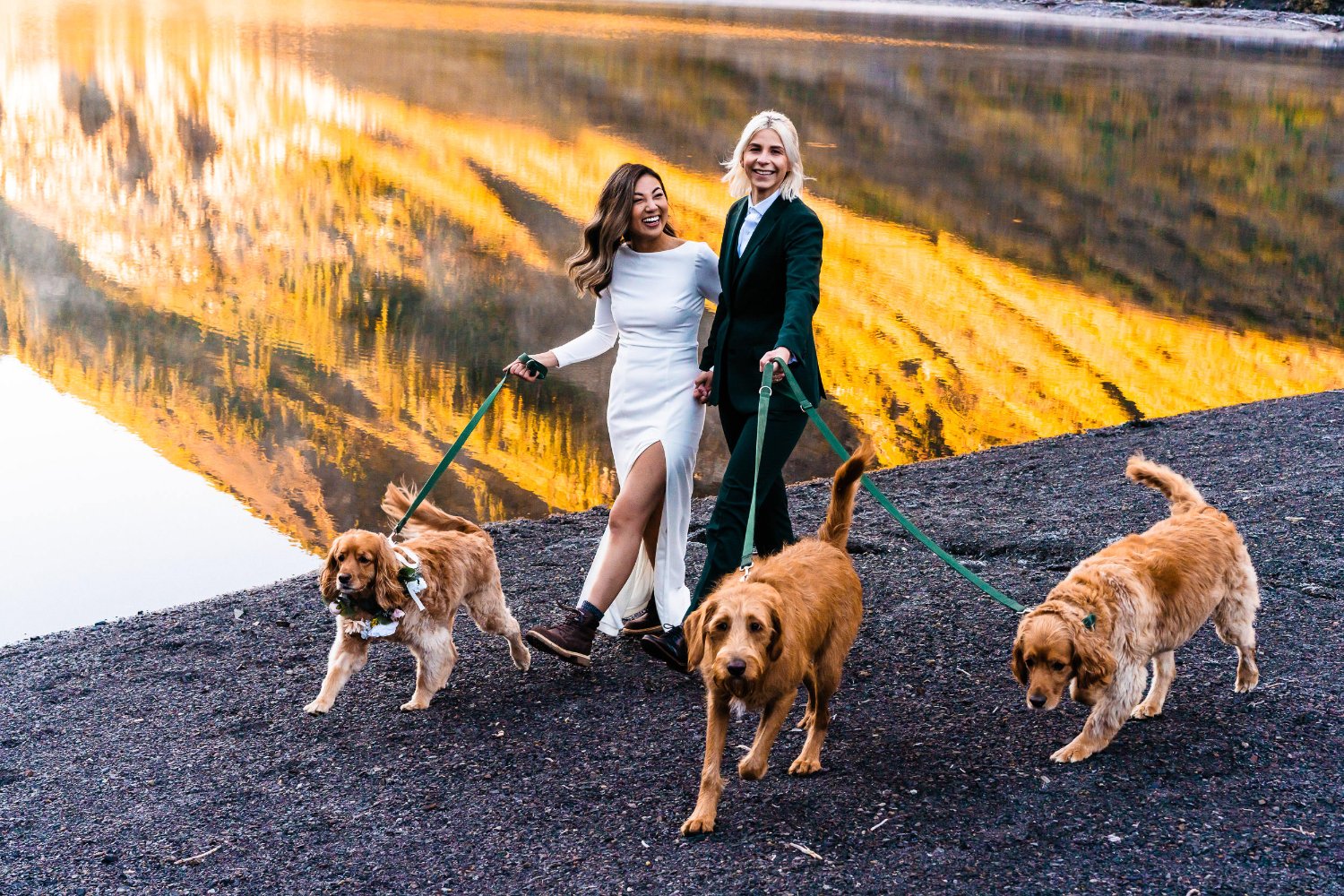 Two brides elopement photos in front of a lake, walking their dogs.