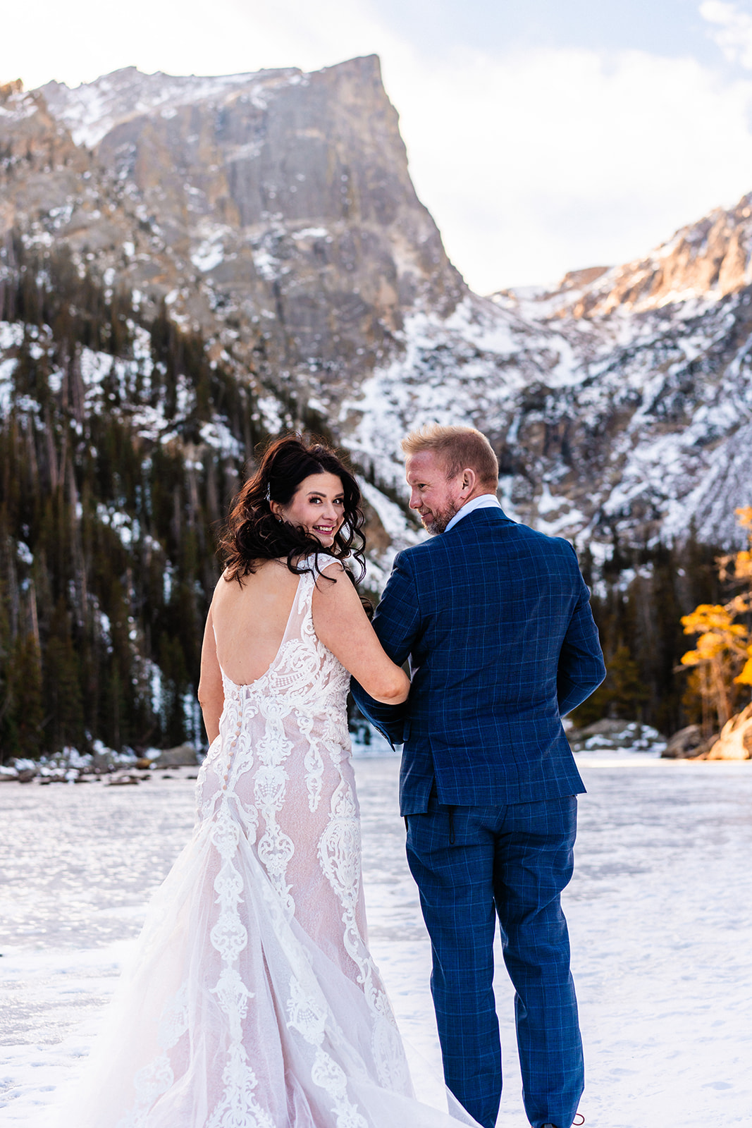 A bride and groom, eloping at one of the best places in Colorado, standing in the snow in front of a mountain.