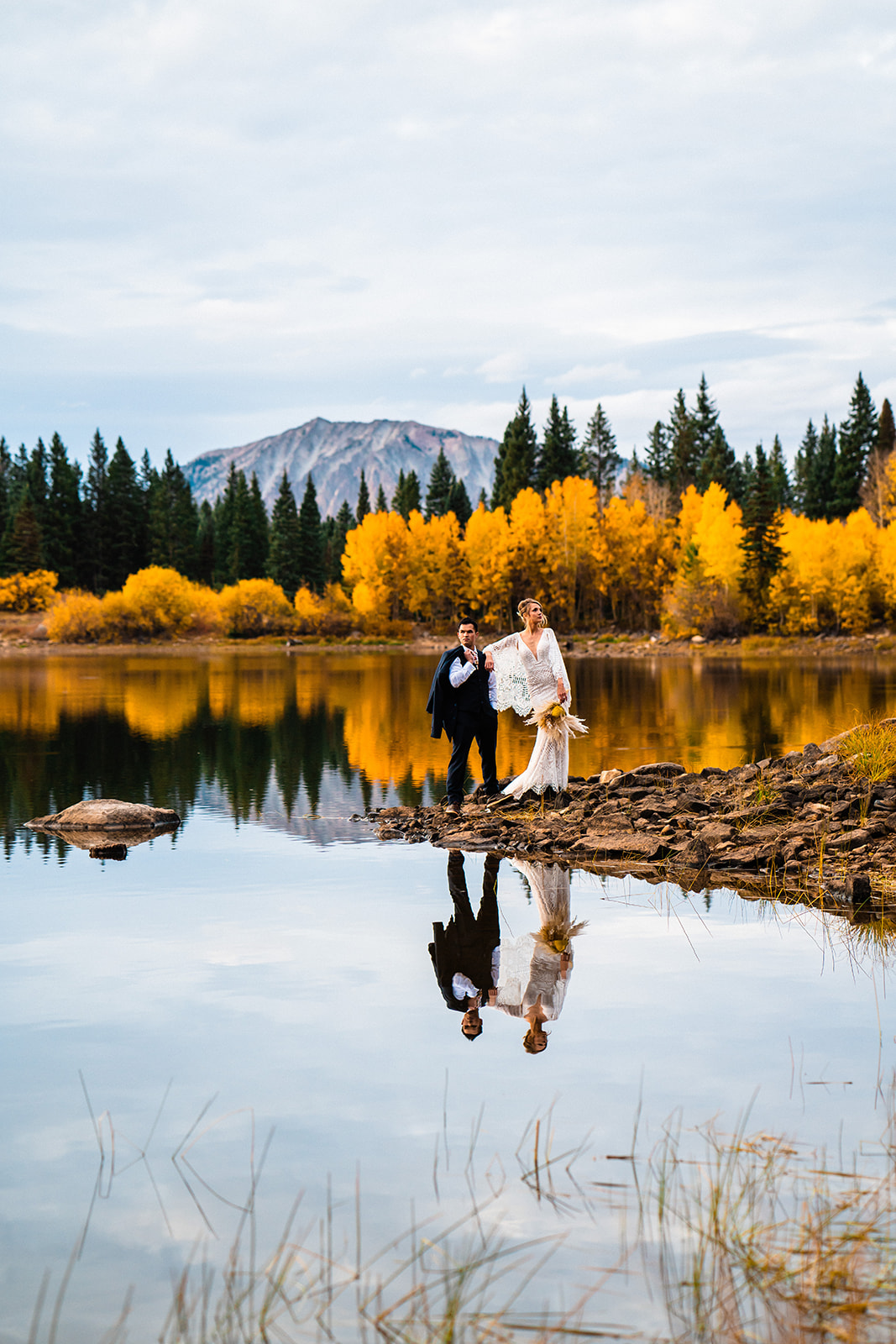 A bride and groom stand atop a lake in one of the best places to elope in Colorado, Crested Butte.