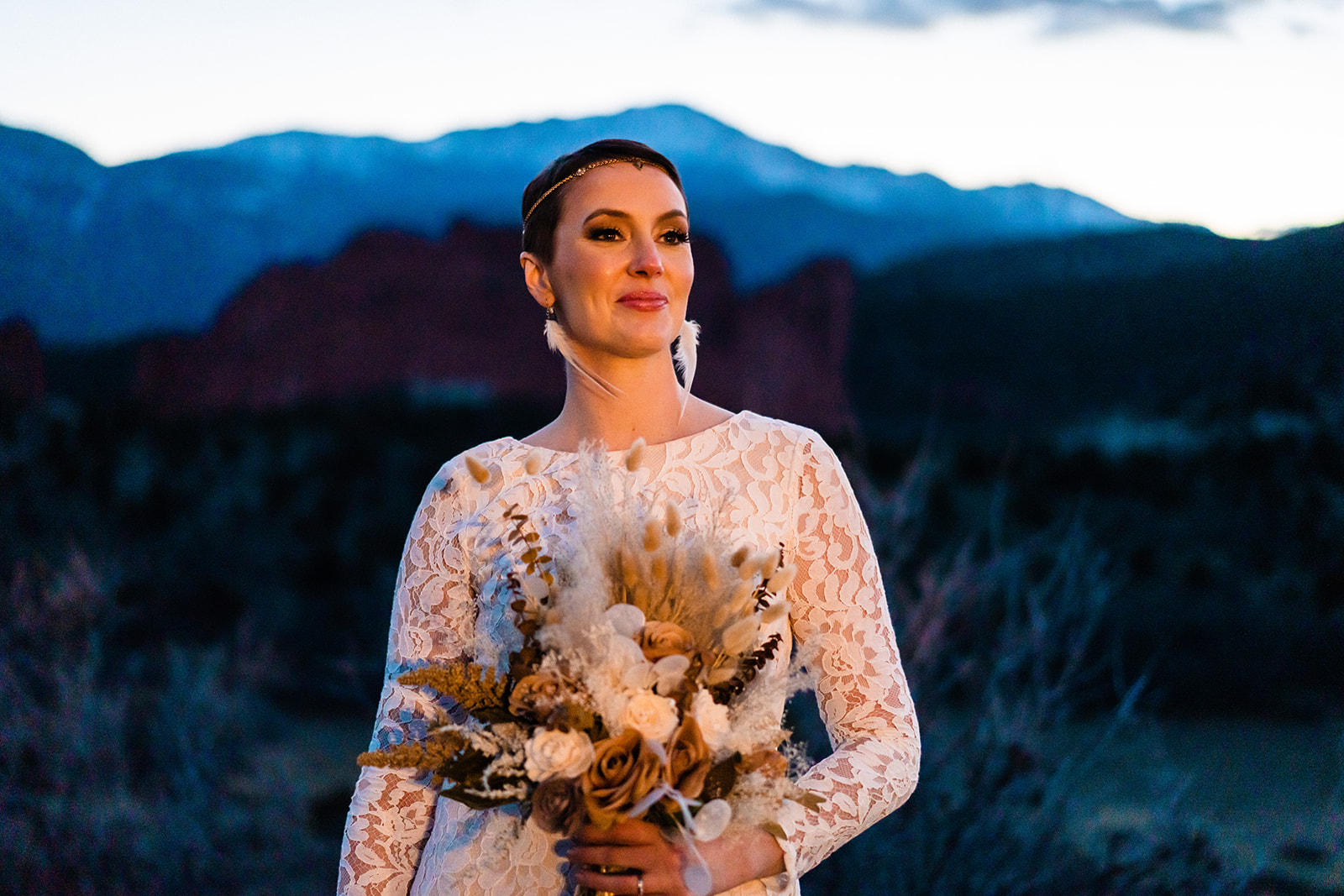 A bride holds her boho bouquet at sunset with her makeup done by a Colorado Springs elopement makeup artist.