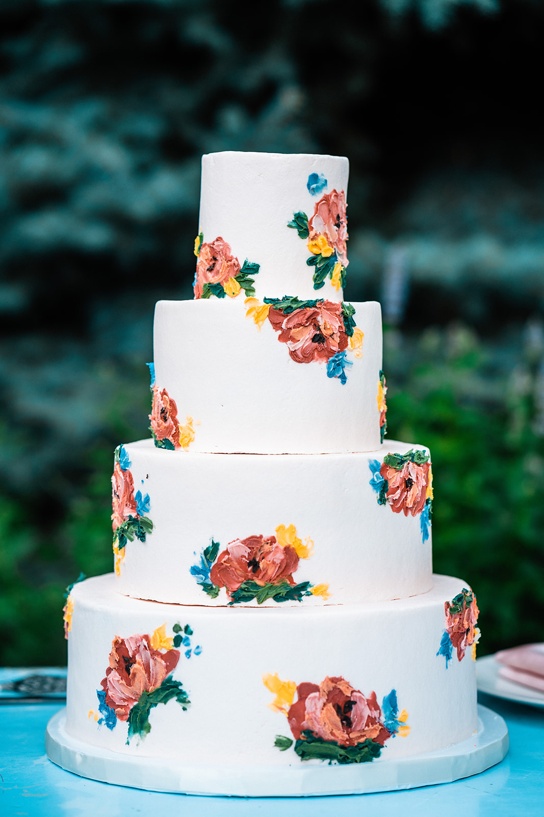 A white wedding cake adorned with flowers was elegantly displayed at the Telluride elopement.