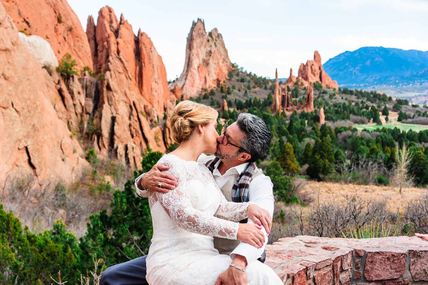 Newlyweds kiss at Valley View Pull-off during their Garden of the Gods elopement with majestic red rock formations in the background.