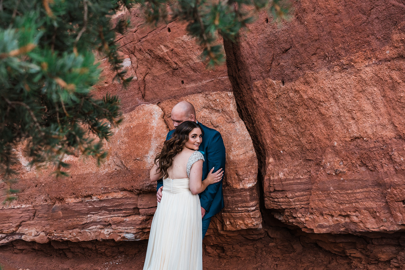 Couple embracing near a red rock formation during their Garden of the Gods elopement.