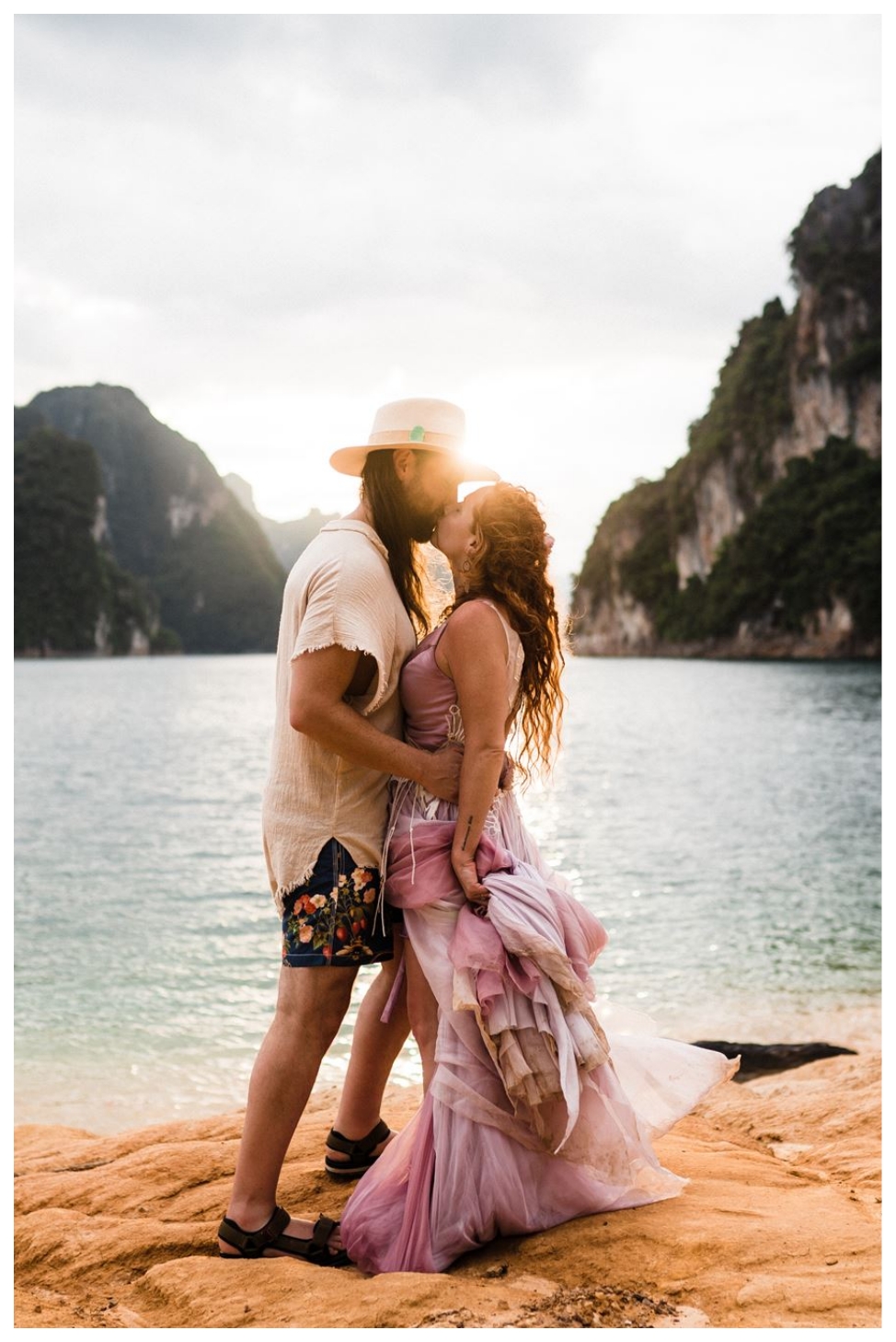 a man and woman kiss overlooking the water and mountains during their adventure elopement