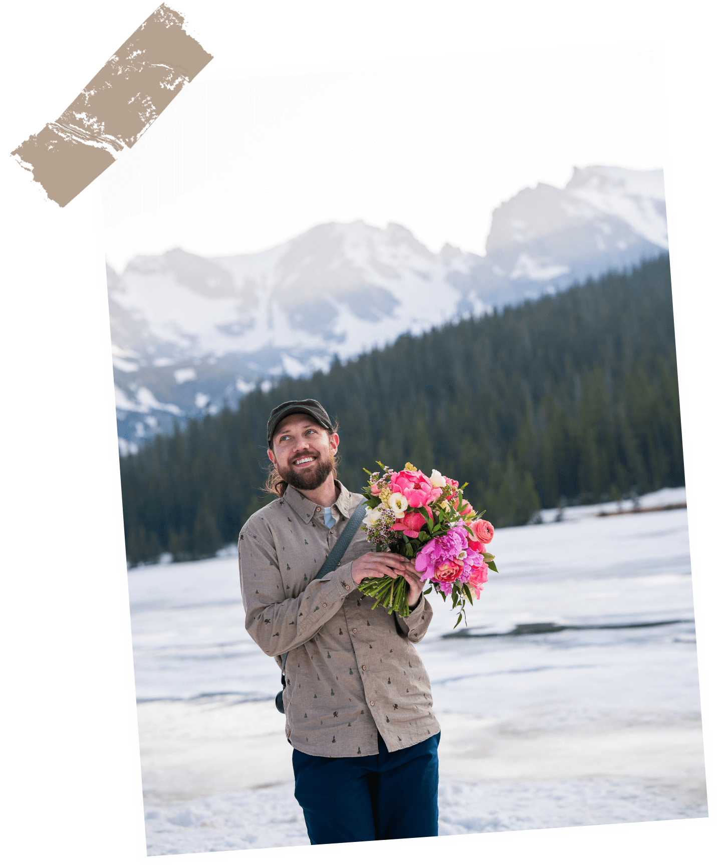 Kevin holding a bouquet of flowers with snowy Colorado mountains in the background.